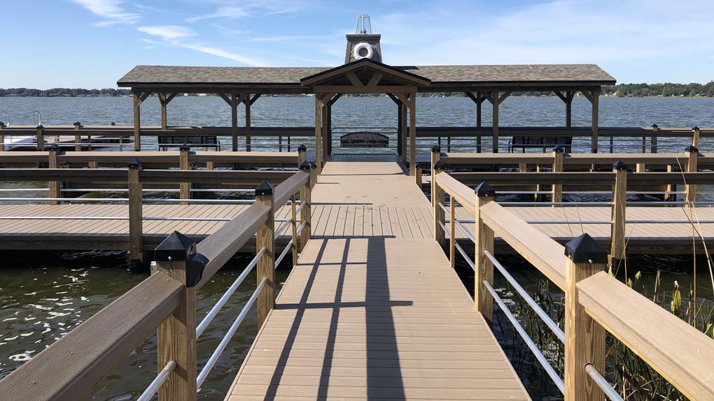 Photo of deck with wood railing to dock with wood railing and arbor
