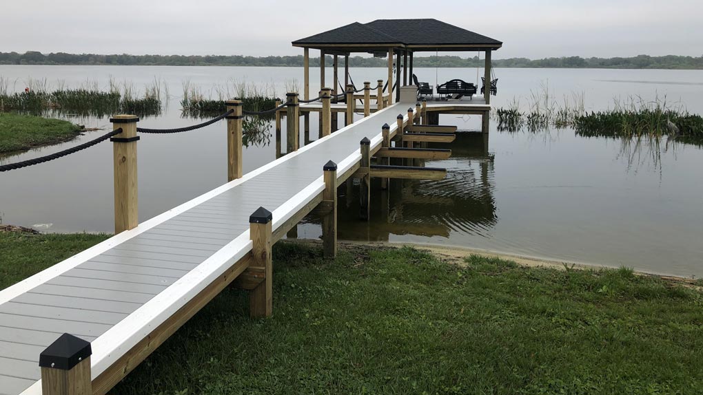 Photo of deck with rope railing to dock with arbor